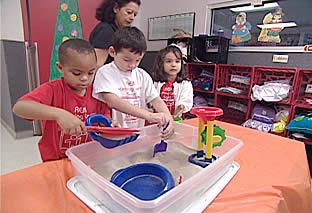 Students doing an activity with sand and water
